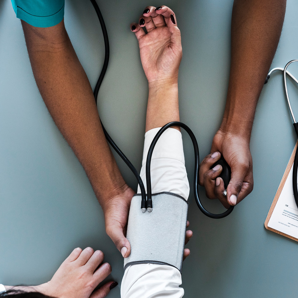 Hands performing a blood pressure check on someone's arm